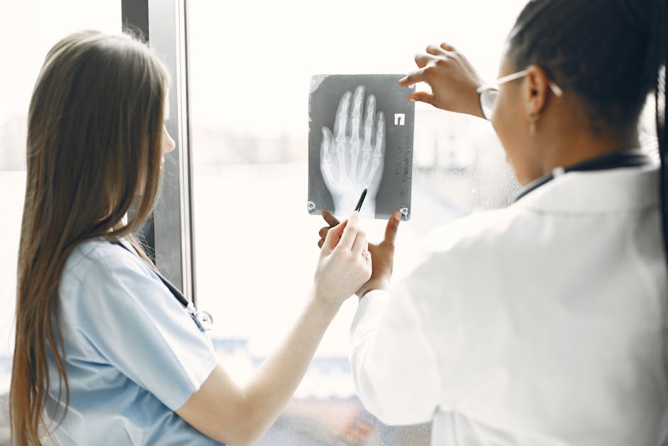 Two doctors examine a hand X-ray in a hospital setting.